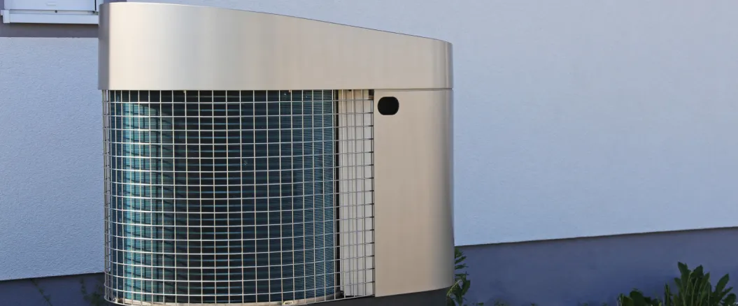 Modern outdoor heat pump unit installed on the exterior wall of a residential building.