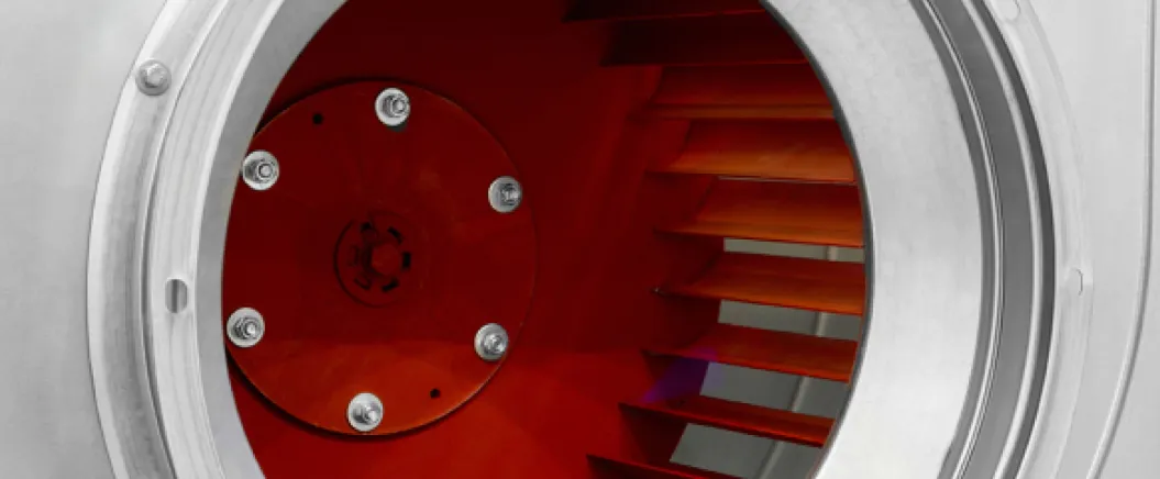 Close-up view of an industrial ventilation fan with red blades and a metallic housing.