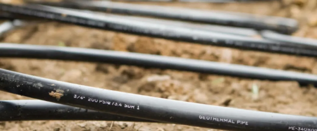 Geothermal pipes installed underground in soil for a renewable energy heating and cooling system.